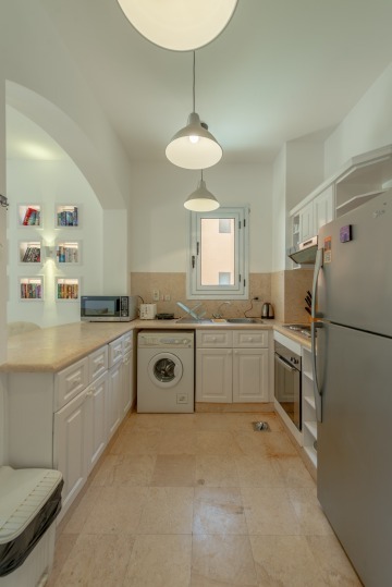 Voll ausgestattete Küche mit Waschmaschine, Mikrowelle, Toaster, Ofen und Wasserkocher