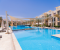 Pool mit Sonnenliegen und Sonnenschirmen 