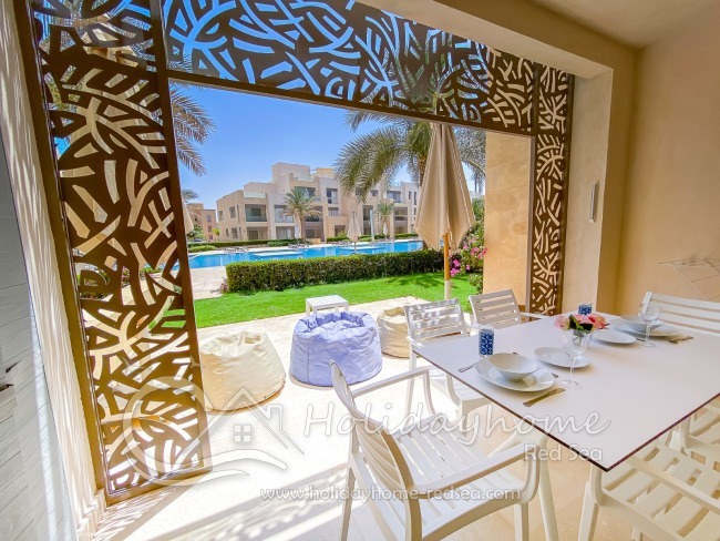 Terrasse mit Sitzgelegenheit und Blick auf den Pool