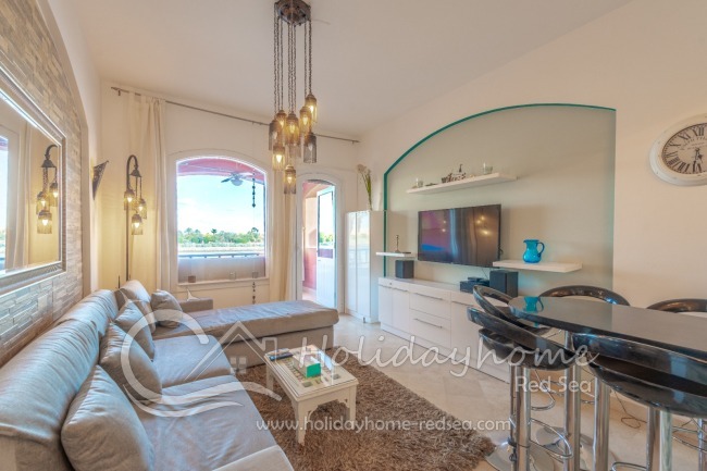 Wohnzimmer mit Zugang zum Balkon und Bartheke zum Essen