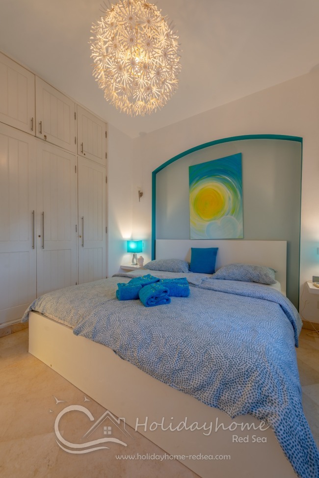 Schlafzimmer mit Doppelbett und Kleiderschrank