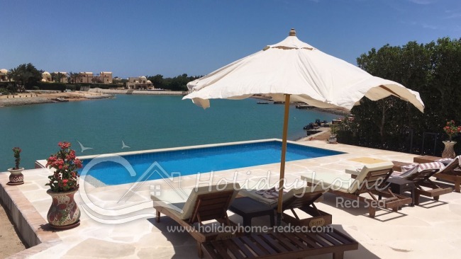 Privater Pool mit Sonnenschirm und Sonnenliegen