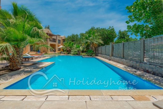 Gemeinschaftspool mit Liegestühlen und Sonnenschirm