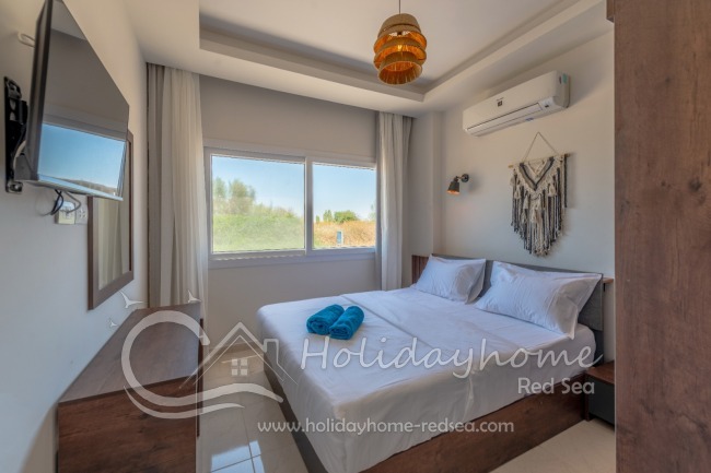 Schlafzimmer mit Doppelbett und smart TV