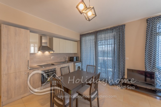 Wohnzimmer und offene Küche mit Zugang zum Balkon