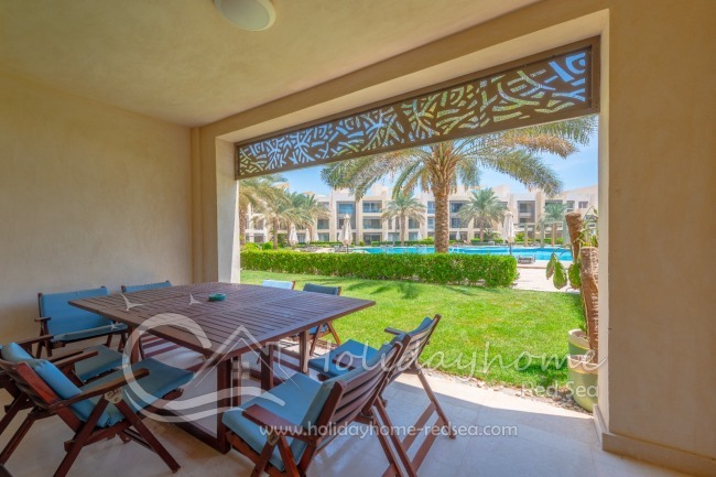 Terrasse mit Sitzgelegenheit und Blick auf den Pool