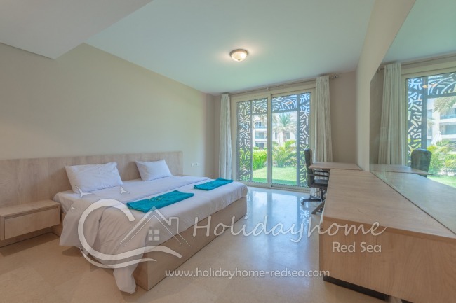 Schlafzimmer mit Doppelbett und Poolblick