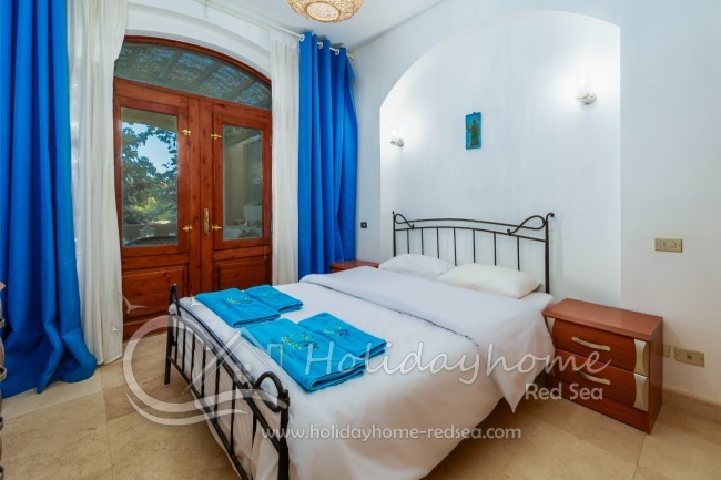 Schlafzimmer 1 mit Doppelbett und Zugang zur Terrasse