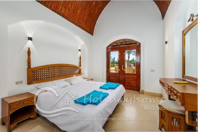 Schlafzimmer 2 mit Doppelbett und eigener Terrasse mit Blick auf den Pool