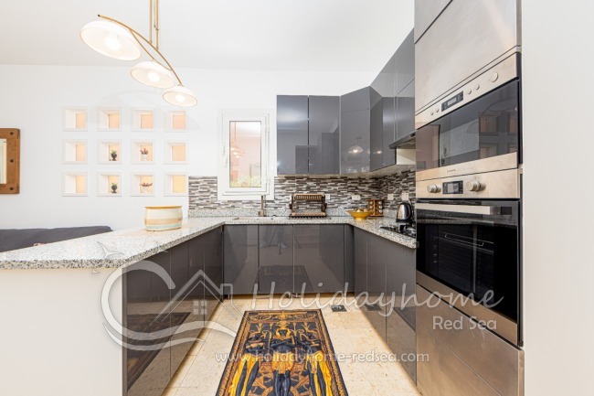 Voll ausgestattete Küche mit Gasherd und elektrischem Ofen. 