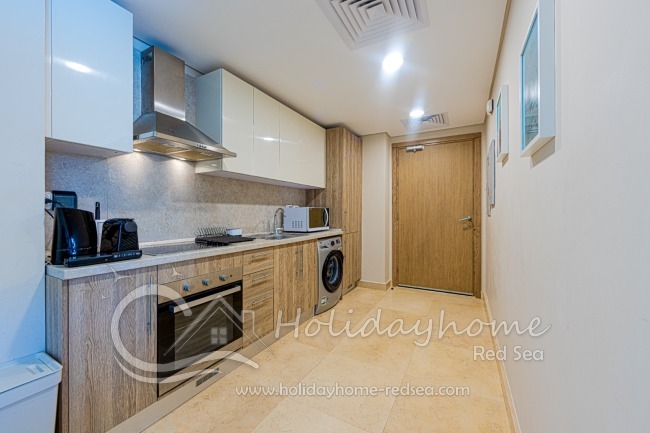 Küche mit Nespresso Maschine, Wasserkocher, Mikrowelle, Herd und Backofen. 