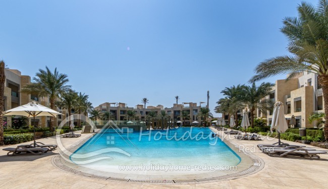 Großer Pool mit Sonnenliegen und Sonnenschirmen