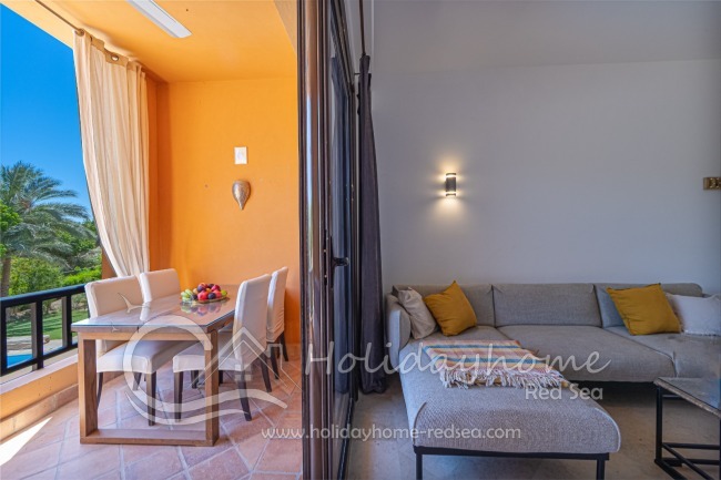 Balkon mit Sitzecke, Esstisch und Blick auf den Pool