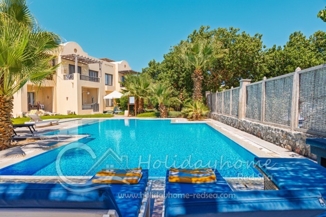 Gemeinschaftspool mit Liegestühlen und Sonnenschirm