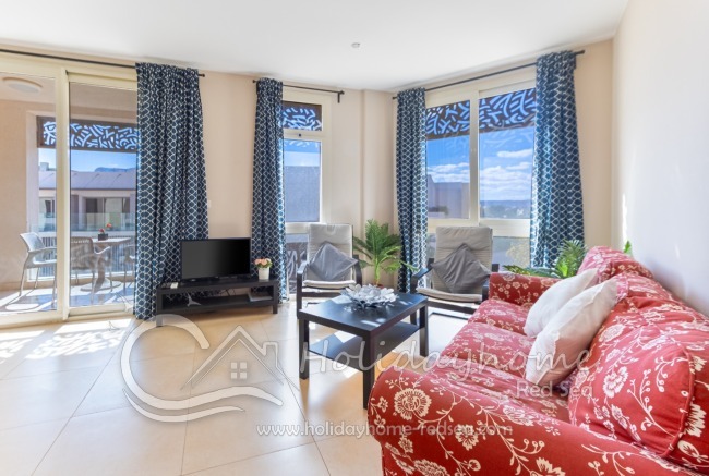 Wohnzimmer mit Fernseher und Balkon