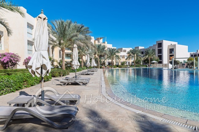 Gemeinschaftspool mit Sonnenliegen und Sonnenschirmen