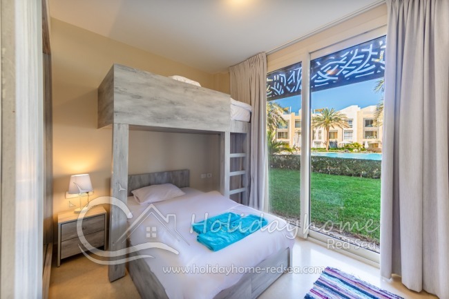 Schlafzimmer 2 mit Etagenbett und Garten-/Poolblick