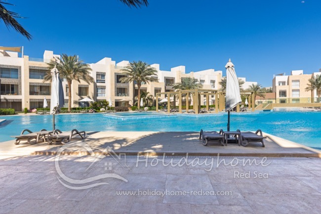 Gemeinschaftspool mit Sonnenliegen und Sonnenschirmen