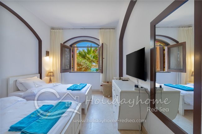 Schlafzimmer 1 mit zwei Einzelbetten und Gartenblick 
