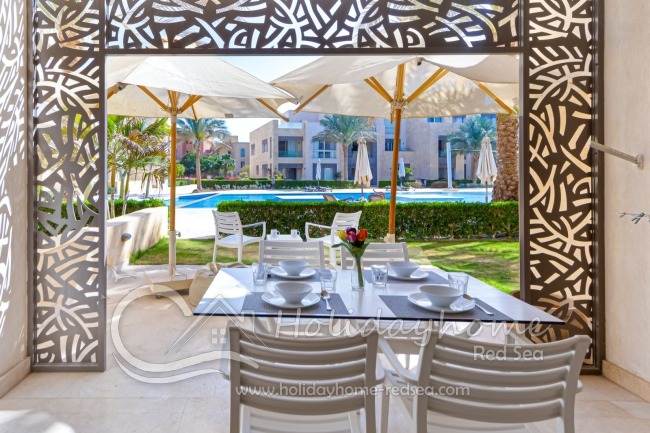 Terrasse mit Sitzgelegenheit und Blick auf den Pool