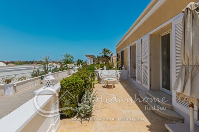 Terrasse an der Seite des Hauses mit gem&uuml;tlicher Sitzecke und Zugang vom Wohnzimmer