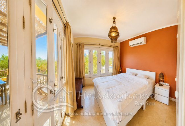 Schlafzimmer mit Doppelbett und Zugang zum Balkon
